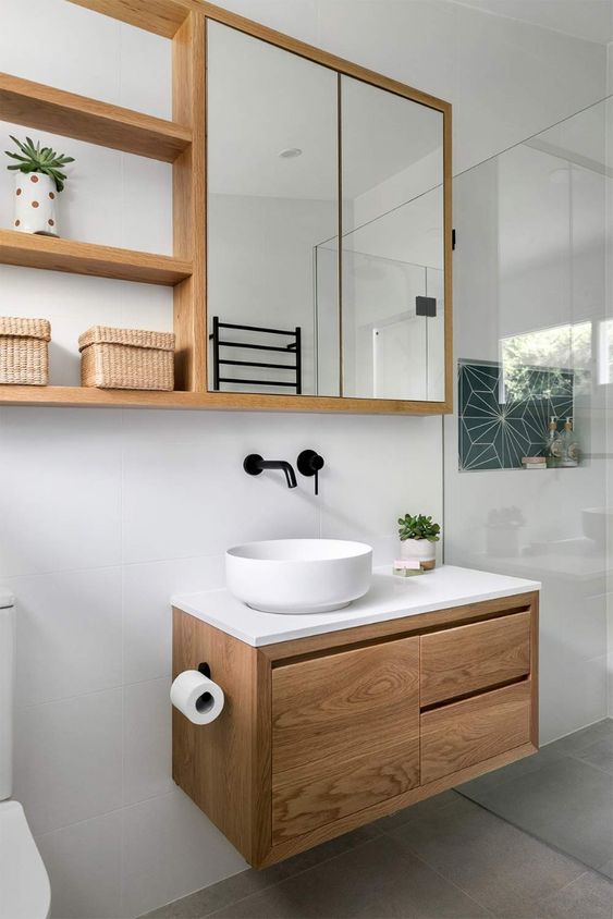 a modern neutral bathroom with a shower space, a mirror cabinet, a floating timber vanity and baskets is a cool space