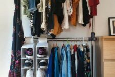 a simple makeshift closet with a double hanging shoe shelf and a dresser for small things next to it is a cool idea