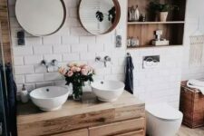 a small and cozy bathroom clad with white subway tiles, a floating vanity and a niche done with wood plus white appliances