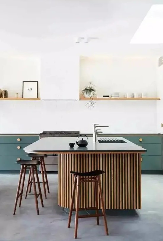 a stylish kitchen with green cabinetry, an open shelf instead of upper cabinets, a large fluted kitchen island with a black countertop and black stools