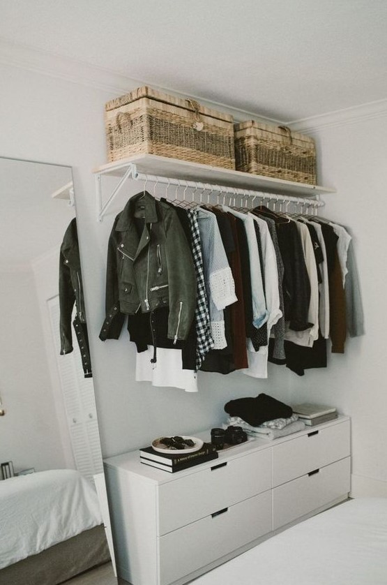 a stylish makeshift closet with baskets for storage on top and an additional white dresser for smaller things under it