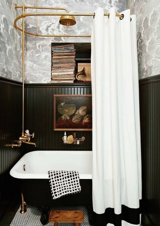 a vintage-inspired bathroom done with wallpaper and black beadboard, a black tub, vintage books and artworks