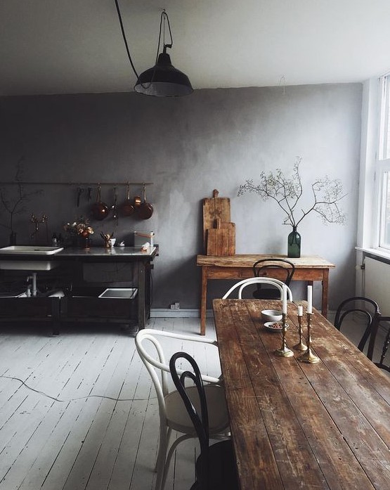 a wabi sabi kitchen with a white plank floor, stained wooden furniture and a metal kitchen island with sinks