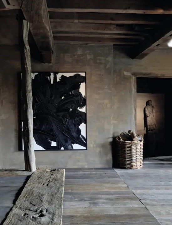 a wabi sabi living room covered with rough wood, planks, beams, artworks and a basket for storage