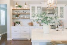 a welcoming white farmhouse kitchen with shaker style cabinets, a white subway tile backsplash, open shelves, pendant lamps
