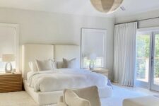 a white bedroom with an upholstered bed and neutral bedding, a daybed, stained nightstands and woven pendant lamps