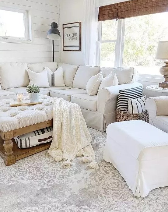a white farmhouse living room with a sectional Ektorp, a white chair and footrest, a low tufted ottoman