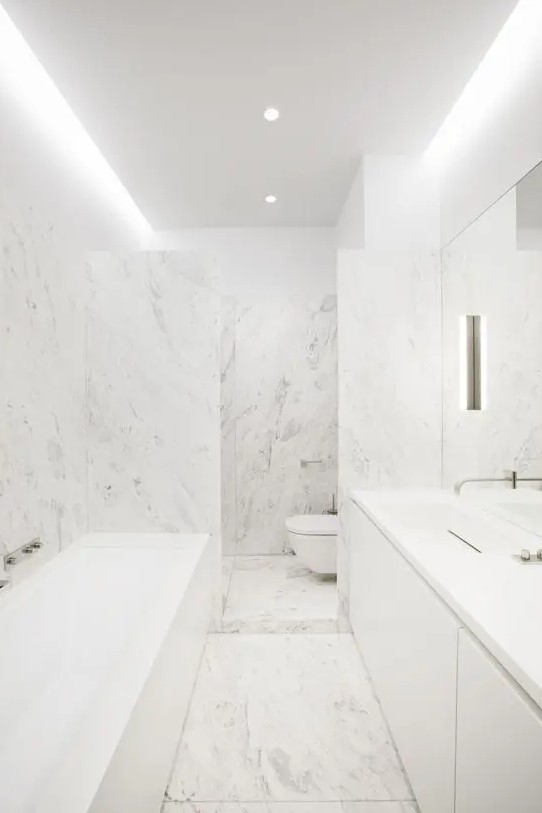 all white marble bathroom with stainless steel touches to make it even more neutral