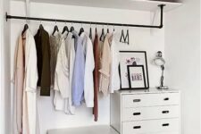 an open shelf for storage, a long railing for hanging clothes, a couple of dressers with drawers as a makeshift closet