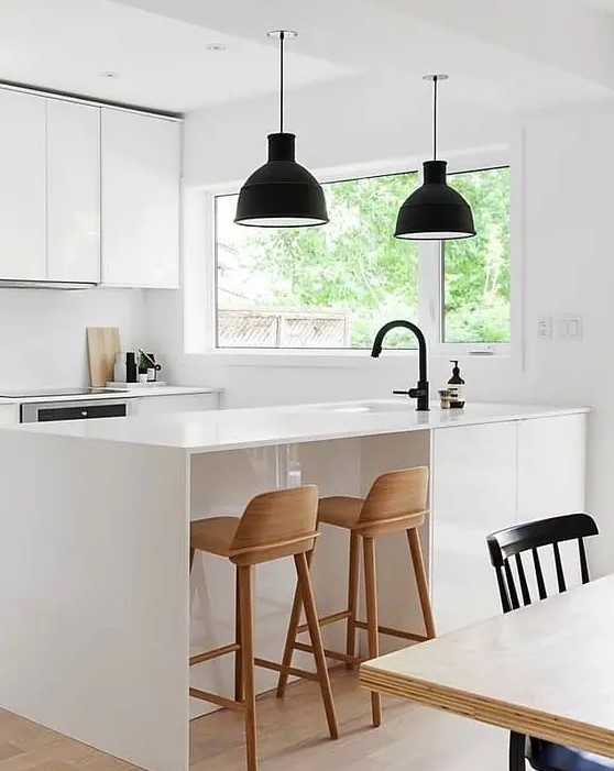 an ultra modern white space with black lamps and wooden stools looks very laconic and chic