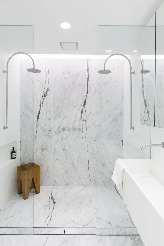white marble tiles and a wooden stool bring texture and eye catchiness to the space
