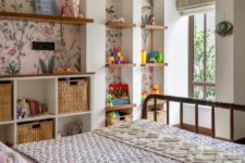 03 a bright kids’ room with a series of arched niches with floral wallpaper, with built-in shelves and baskets, with toys and decor