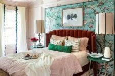 04 a colorful vintage bedroom with paneling, a bright floral wall, a burgundy bed, colorful bedding and a crystal chandelier