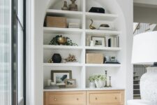 10 a large arched niche with built-in shelves and storage units, with books, decor and artwork is a stylish addition to living room decor