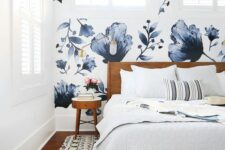 10 a lovely bedroom with a bold blue floral accent wall, a stained bed and nightstands, neutral bedding and a printed rug