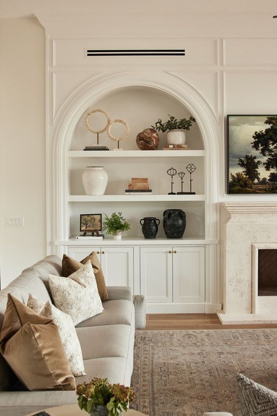 a neutral living room accented with an arched niche with decor, potted plants and artwork is a lovely idea for any space