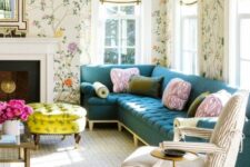 14 a pretty and chic living room with bright floral wallpaper, a navy sectional, a striped chair, a non-working fireplace, a bold neon yellow ottoman