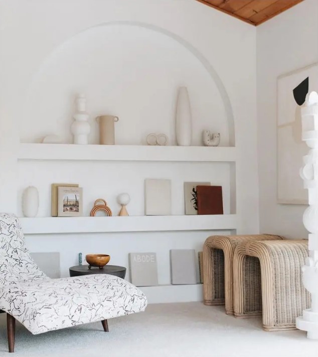 a neutral living room with an arched niche showing off vases and books instead of some furniture