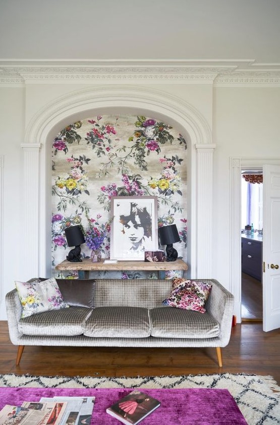 a refined and bold living room accented with chic floral wallpaper and matching pillows is very cool and welcoming