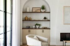16 a neutral living room with an arched niche with stained shelves and a cabinet, with beautiful decor that adds interest to the space