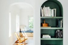 17 a neutral space with a green arched wall niche with shelves, with books and baskets that is a bold color touch to the space