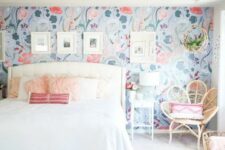 21 an airy bedroom with a bright floral accent wall, a white bed with neutral bedding, a blue boho rug, a rattan chair and white nightstands