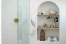 23 adding interest to the bathroom, an arched niche with shelves also provides the space with some storage