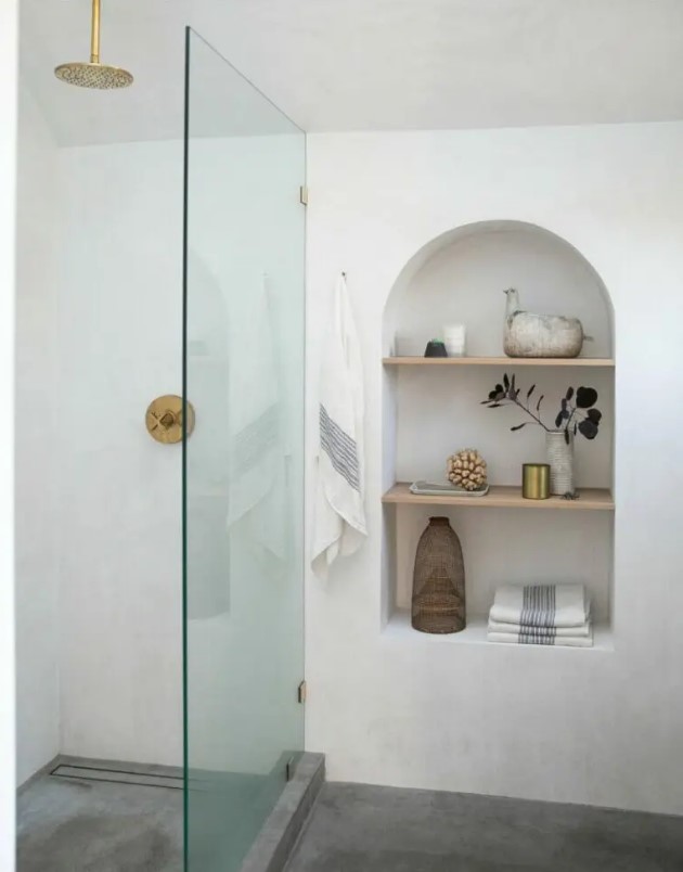 adding interest to the bathroom, an arched niche with shelves also provides the space with some storage