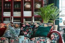 25 a moody living room with dark floral wallpaper and a matching sofa, floral pillows, a rich-stained buffet, a couple of coffee tables