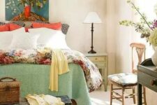 27 a vintage farmhouse with printed wallpaper, printed and colorful bedding, vintage furniture and a bright artwork