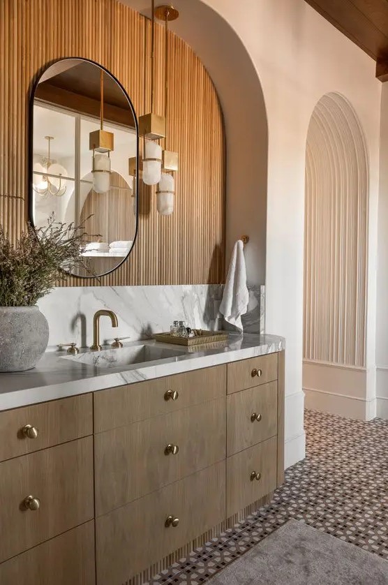a contemporary bathroom with an arched niche clad with wood, a curved mirror, a floating vanity and cool pendant lamps