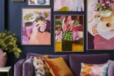 35 a moody living room with navy walls, a purple sofa and a pink chair, a rust pouf and a super bold floral gallery wall