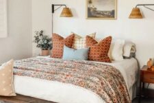 38 a welcoming bedroom in neutrals with a bed with floral and other printed bedding, a stained bench, a chandelier, stained nightstands
