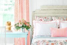 39 an airy cottage bedroom with slatted walls, a shabbychic bed with bright floral bedding, a mint blue vanity and bold coral curtains