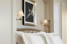 44 a sophisticated tan bedroom with an arched niche with sconces and art, with an upholstered bed with neutral bedding