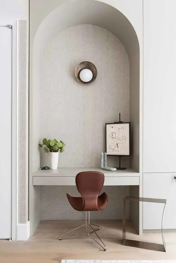 an arched niche with a wall sconce, an artwork and a potted plant can act as a tiny working space