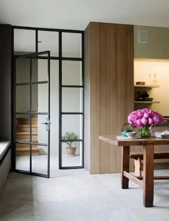 French door with black metal framing to separate the hallway from the kitchen