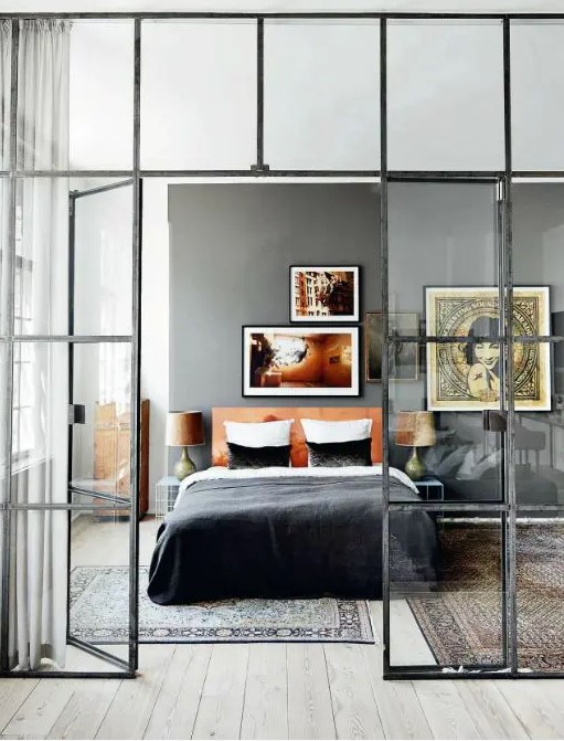 French doors with a modern look in black frames to separate the bedroom from the rest of the apartment