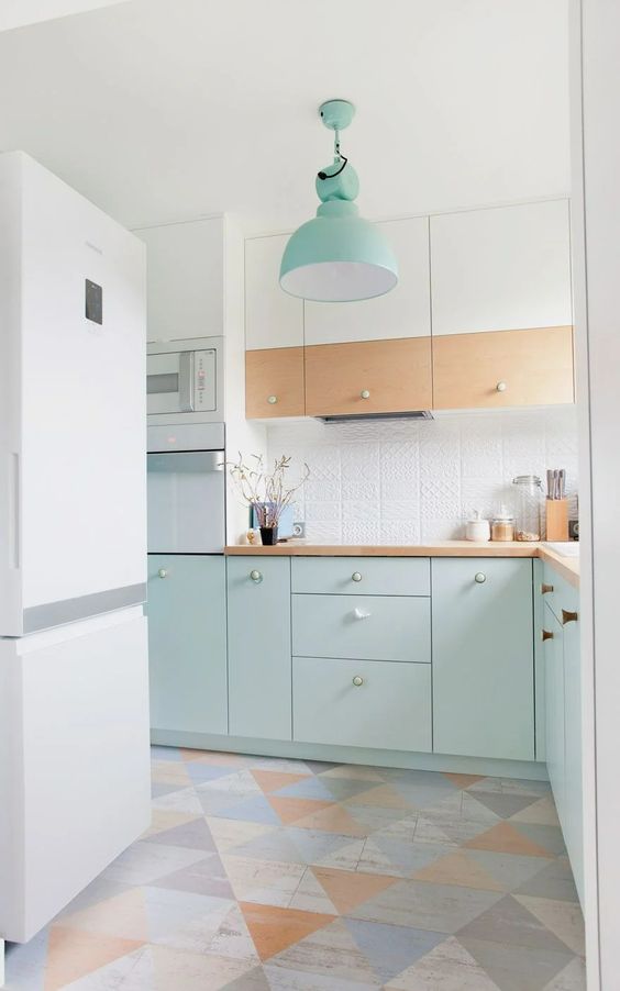 a Scandinavian kitchen with stained and mint blue cabinets, a patterned tile backsplash, butcherblock countertops and a colorful floor