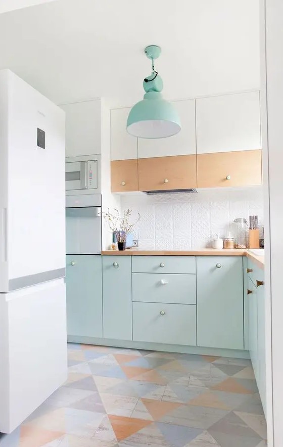 a Scandinavian kitchen with white, stained and mint blue cabinets, a white textural backsplash, stained countertops, a geo floor