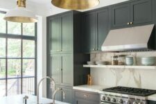 a black farmhouse kitchen with shaker cabinets, a white quartz backsplash and countertops, white and gold pendant lamps
