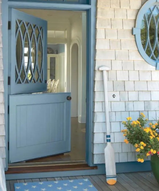 a blue Dutch door with a creative glass top part and shingles look cool together and make up a cool coastal cottage