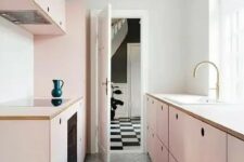 a chic girlish kitchen with simple blush plywood cabinets and a grey tiled floor flooded with much natural light