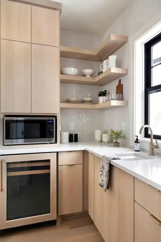 a chic light-stained kitchen with sleek flat panel cabinets, white stone countertops and a white glossy tile backsplash