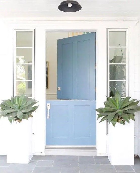 a clean modern beach house entrance with large succulents and a blue Dutch door