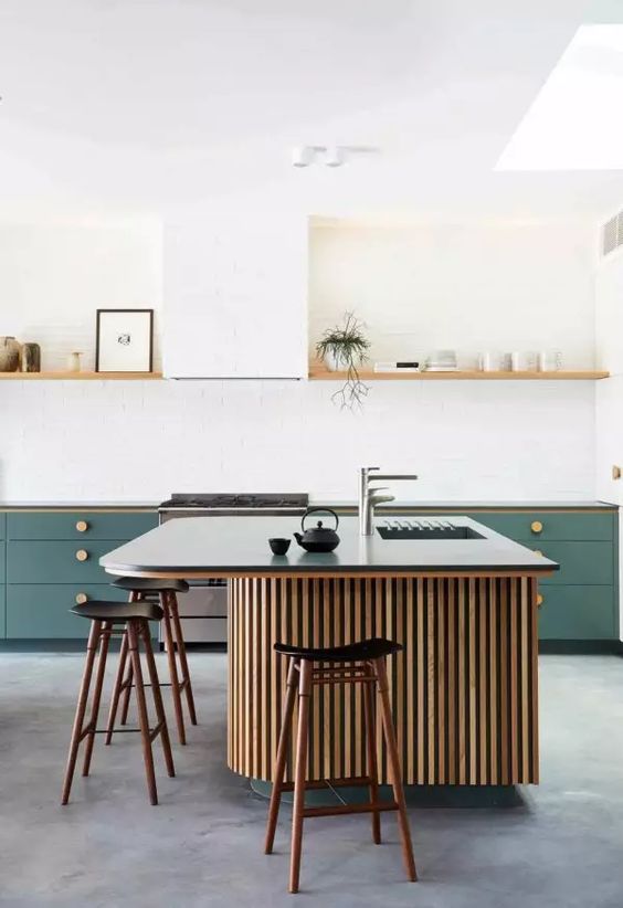 a contemporary kitchen with green cabinets, a large curved kitchen island with fluting, an open shelf instead of upper cabinets
