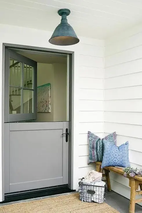 a cozy porch with a bench, a wire bakset and a grey Dutch door for a vintage feel plus a ceiling lamp