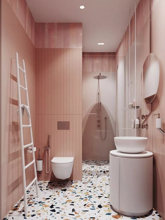 a delicate blush bathroom with a bright terrazzo floor and white furniture and appliances to refresh the space