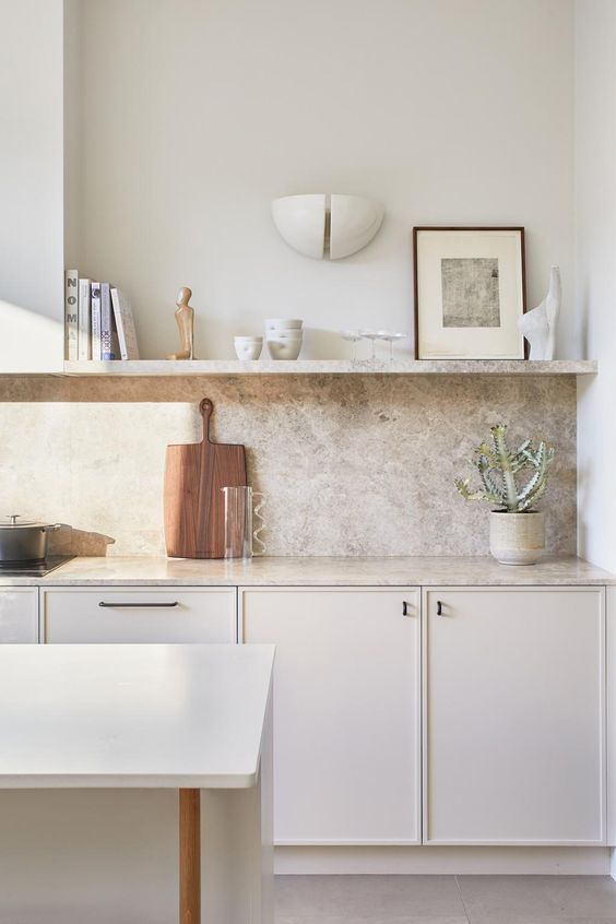 a delicate neutral kitchen with a grey quartz backsplash and countertops, an open shelf is serene and airy