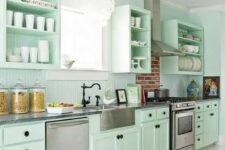 a fresh and beautiful mint green kitchen with black knobs, fixtures and much white to make it look more ethereal